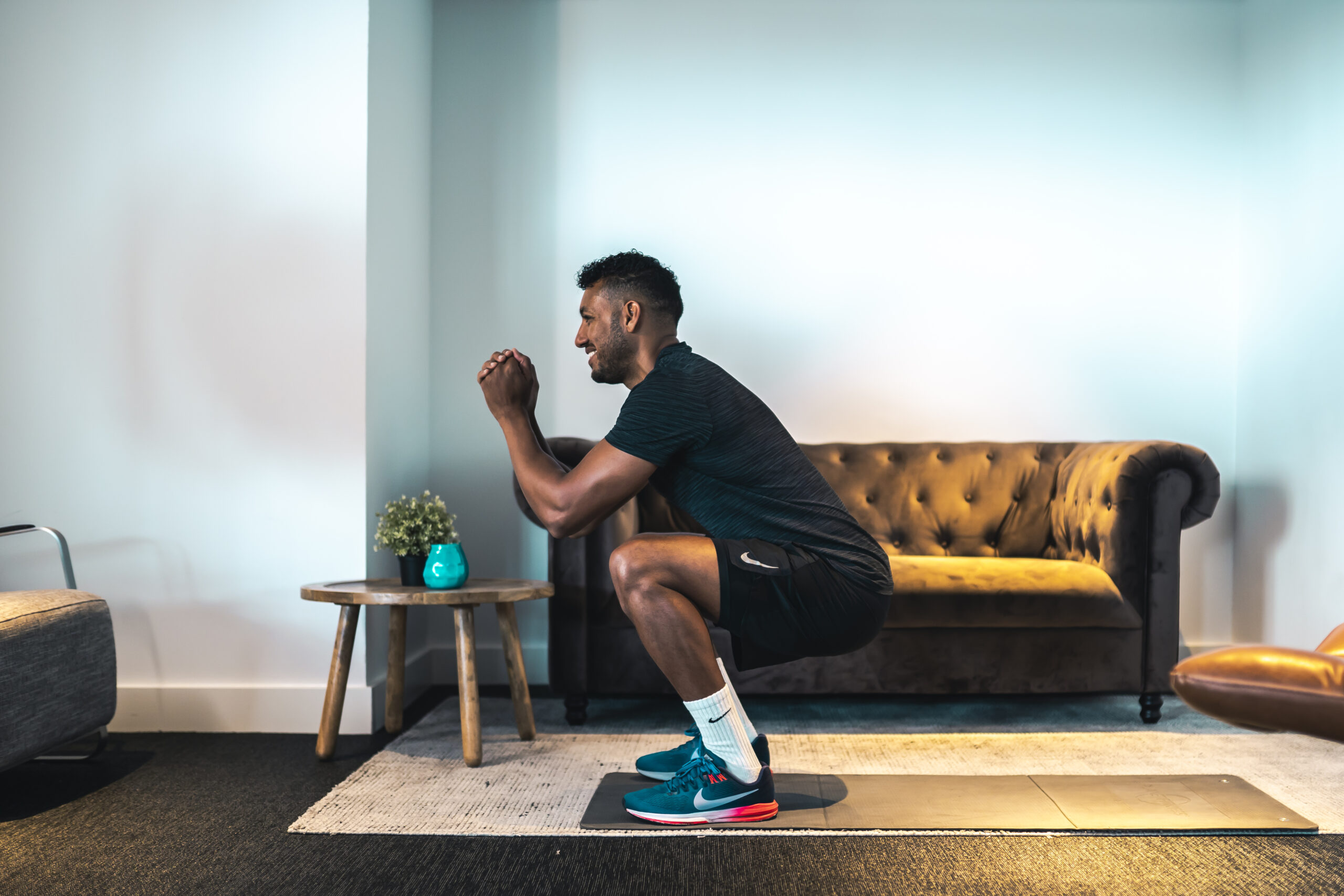 man doet squat in huiskamer