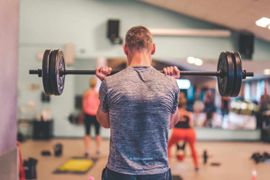 man met barbell in groepsles