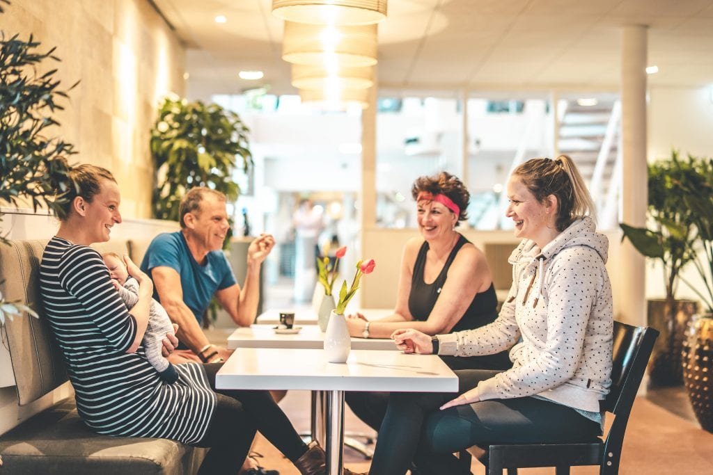mensen aan tafel kletsen gezellig in de lounge