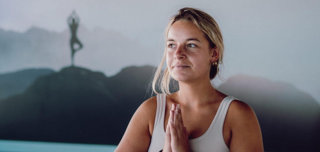 vrouw doet handen op elkaar in yoga pose
