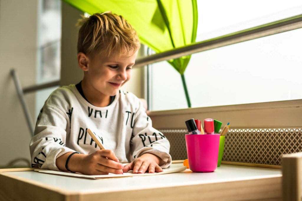 kind tekent aan tafel bij kinderoppas mylife
