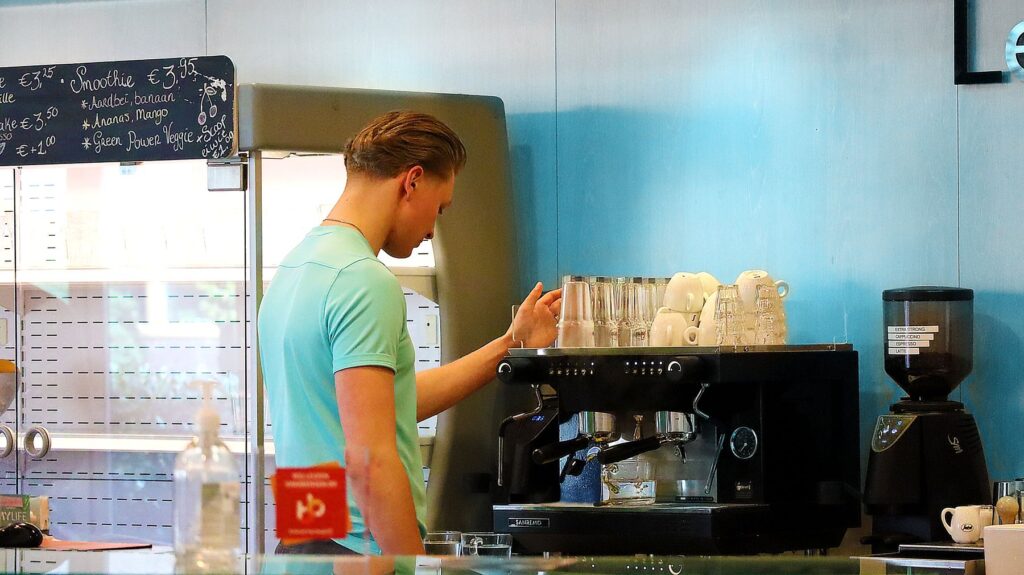 man maakt een koffie