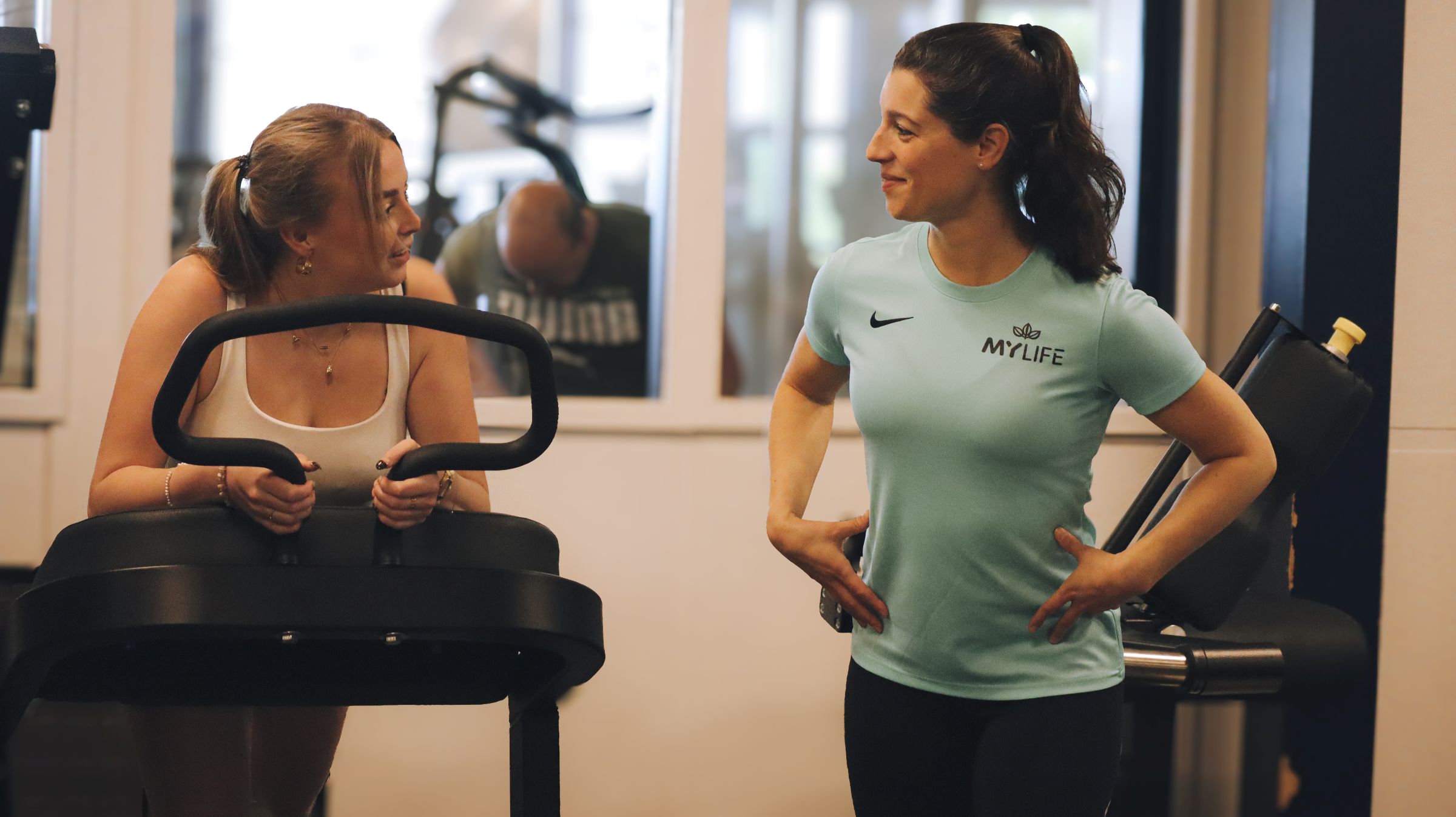 fitnessinstructeur praat met sporter