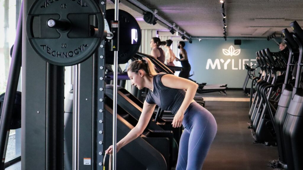 vrouw stelt fitnessapparaat in