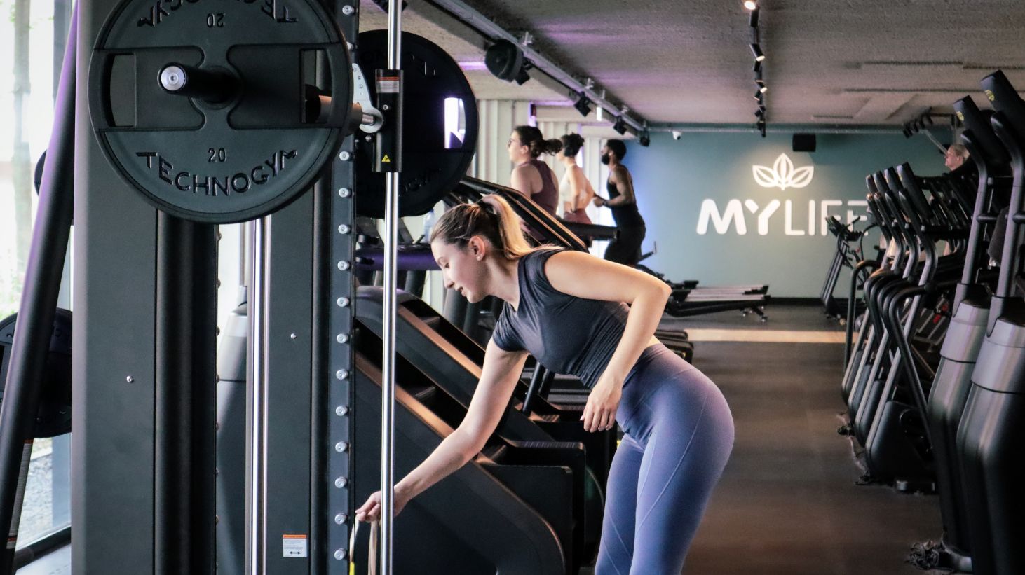 vrouw stelt fitnessapparaat in